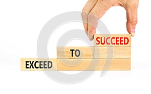 Exceed to succeed symbol. Concept words Exceed to succeed on beautiful wooden blocks. Beautiful white table white background.