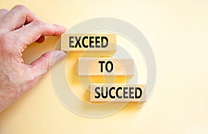 Exceed to succeed symbol. Concept words Exceed to succeed on beautiful wooden blocks. Beautiful white table white background.