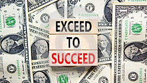 Exceed to succeed symbol. Concept words Exceed to succeed on beautiful wooden blocks. Dollar bills. Beautiful dollar bills