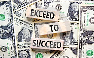 Exceed to succeed symbol. Concept words Exceed to succeed on beautiful wooden blocks. Dollar bills. Beautiful dollar bills