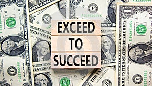 Exceed to succeed symbol. Concept words Exceed to succeed on beautiful wooden blocks. Dollar bills. Beautiful dollar bills