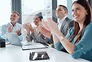 Excellence is simply a part of business for them. a group of businesspeople applauding during a meeting in an office.