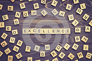 Excellence word wood block on table for business concept.