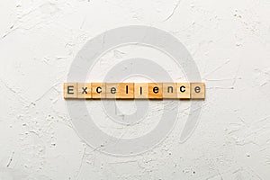 Excellence word written on wood block. Excellence text on cement table for your desing, concept