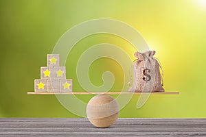Excellent business five star rating experience on wooden block with money bag on seesaw balancing, meaning business gain money