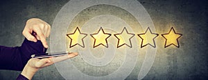 Excellent customer service concept. Man giving five star rating in online survey