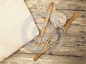 Excellent mocap two old wooden spindle with a ball of wool thread for the manufacture of woolen threads on a wooden background