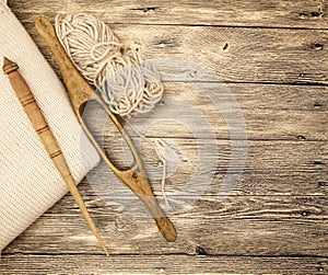 Excellent mocap two old wooden spindle with a ball of wool thread for the manufacture of woolen threads on a wooden background