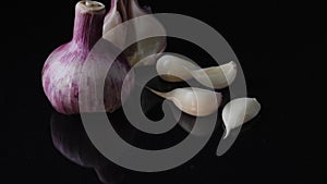 Excellent side view close up of fresh young head of garlic. Frame. Close-up of garlic on black background