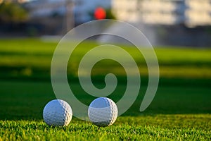 Excellent well-kept green grass lawn on large golf course, green section with big white foam balls for beginners on Tenerife