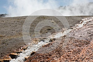 Excelsior Geyser run off hot steaming water flowing from excelsior crater at Yellowstone National Park, Wyoming photo