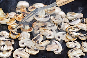 Cooking grilled mushrooms champignons, they are a party food photo