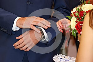 Exchange of wedding rings. Bride places the ring on the groom`s hand.