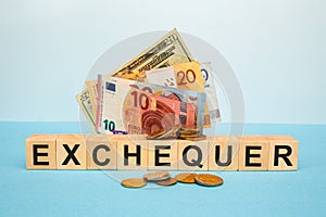 EXCHEQUER word written on wood cubes on the background of various banknotes photo