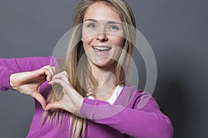 Excited 20s woman showing heart shape with hands