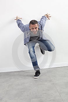 Excited 40s man standing against wall for energy and movement