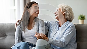 Excited adult daughter and elderly mum have fun at home