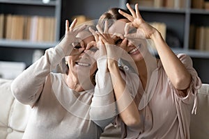 Excited adult mother and daughter make funny gestures posing