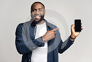 Excited Africal man with smartphone in the hand isolated on gray background photo