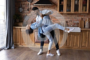 Excited African American couple dancing in kitchen, enjoying romantic date