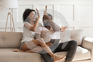 Excited african American couple give high five celebrating success