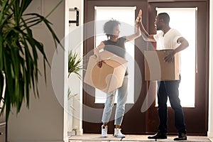 Excited African American couple giving high five, celebrate relocation