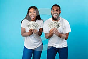 Excited African American couple holding a lot of dollar cash
