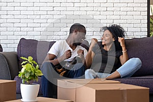 Excited African American couple in love celebrating moving day