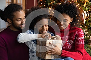 Excited African American family with kid open Christmas gifts