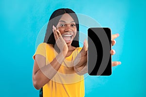 Excited African American Lady Showing Phone Screen On Blue Background photo