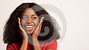 Excited African American Lady Touching Face And Looking Aside With Amazement