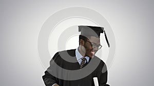 Excited african american male student in graduation robe dancing