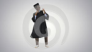 Excited african american male student in graduation robe dancing