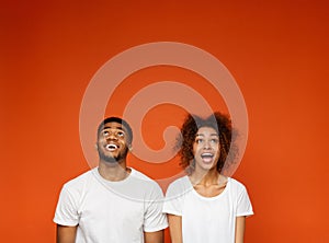 Excited african-american man and woman looking upwards