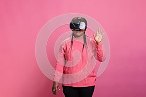 Excited african american woman wearing virtual reality headset playing video games having digital experience