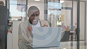 Excited African Businessman Celebrating Success on Laptop in Office