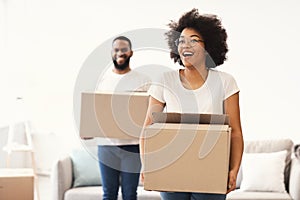 Excited African Couple Carrying Moving Boxes Entering Own Home