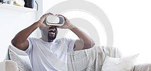 Excited african guy enjoying virtual reality in VR goggles