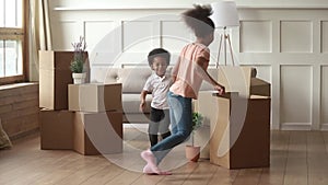 Excited african kids running playing with boxes on moving day