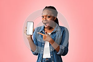 Excited African Lady Showing Phone Blank Screen Over Pink Background