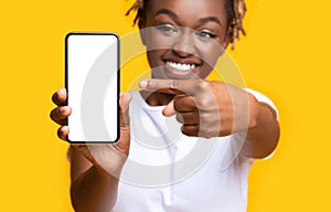 Excited african lady showing smartphone with white screen