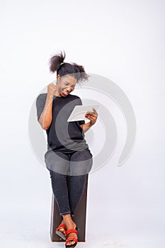 Excited african lady using a tablet computer, feeling happy