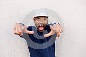 Excited african man pointing at front with surprised expression