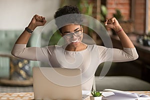 Excited african woman feeling winner rejoicing online win on laptop