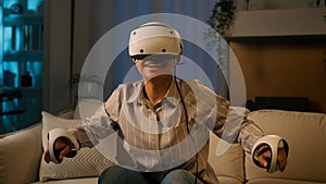 Excited African woman playing virtual reality game at home night happy American girl in gaming simulation VR helmet