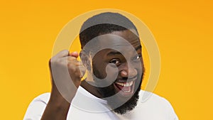 Excited Afro-American man showing yes gesture, happy lottery winner, close up