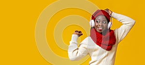 Excited afro girl with wireless headset listening to music, dancing