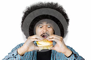 Excited Afro man eating a burger