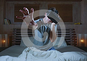 Excited and amazed man wearing VR virtual reality goggles device playing internet 3D simulator game enjoying exciting and