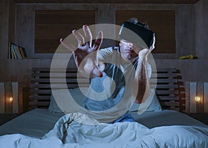 Excited and amazed man wearing VR virtual reality goggles device playing internet 3D simulator game enjoying exciting and